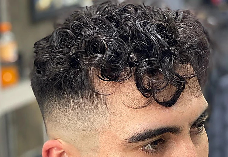 Cabello rizado arriba con fade alto en los lados